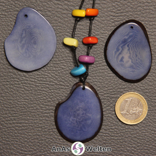 Drei blaue Tagua-Nuss-Scheiben. Eine davon ist mit 6 Tagua-Nuss-Splittern in den Chakra-Farben als Kette gebunden.