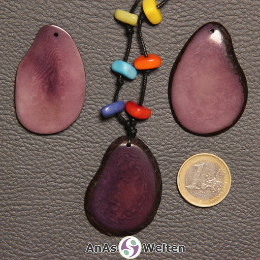 Drei lila Tagua-Nuss-Scheiben. Eine davon ist mit 6 Tagua-Nuss-Splittern in den Chakra-Farben als Kette gebunden.
