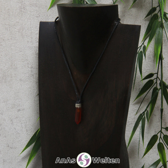 Eine dunkelrote Karneol Stift-Anhänger klein Kette mit einem Metallelement über dem Edelstein an einer dunklen Büste.