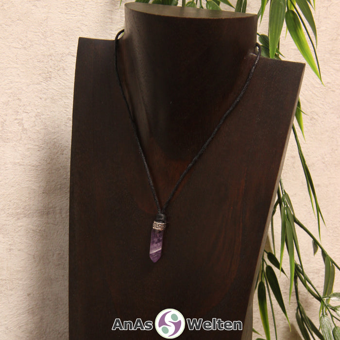 Eine lila-weiße Amethyst Stift-Anhänger klein Kette mit einem Metallelement über dem Edelstein an einer hellen Büste.