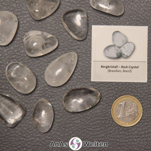 Mehrere Beispiele für den Bergkristall Trommelstein. Daneben liegt der Sticker.