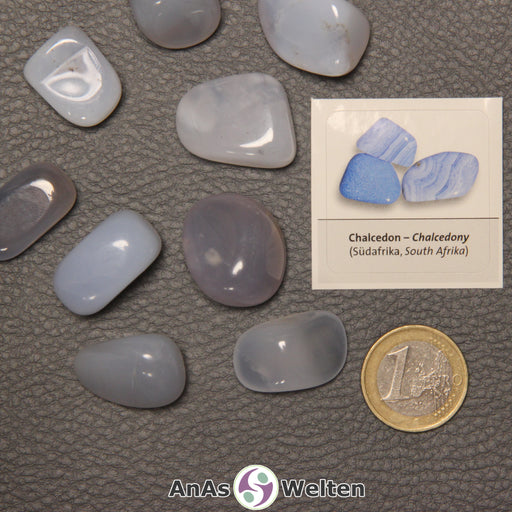 Mehrere Beispiele für den Blauer Chalcedon Trommelstein. Daneben liegt der Sticker.