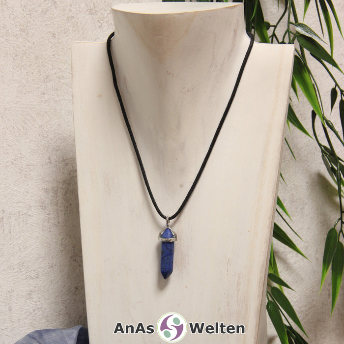 Ein Dumortierit Stift-Anhänger groß mit Metallöse, der mit einem schwarzen Baumwollband um eine helle Büste gehängt wurde