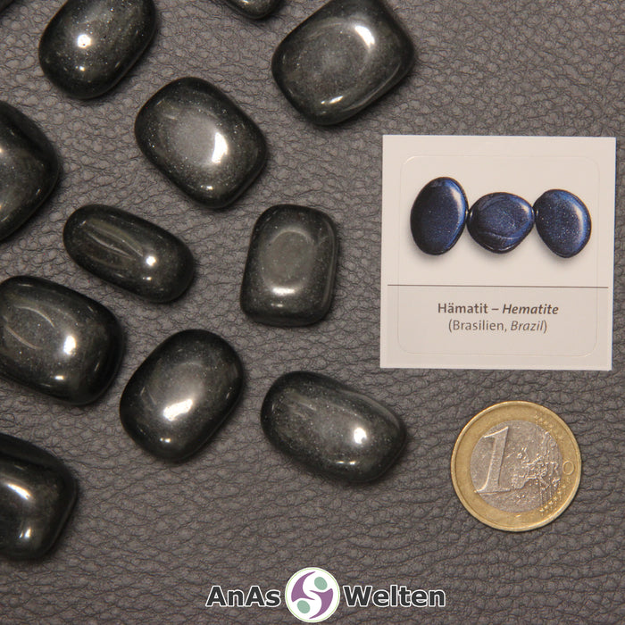 Mehrere Beispiele für den Hämatit Trommelstein. Daneben liegt der Sticker.