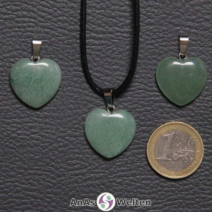 Drei Herzanhänger aus Aventurin nebeneinander. Einer befindet sich an einem schwarzen gewachsten Baumwollband.