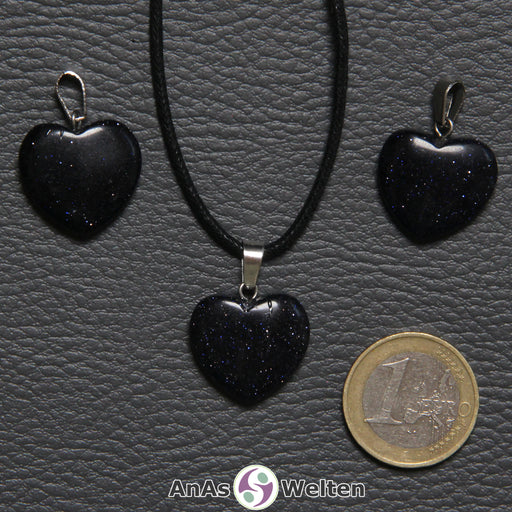 Drei Herzanhänger aus Blaufluss nebeneinander. Einer befindet sich an einem schwarzen gewachsten Baumwollband.
