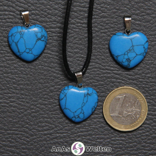 Drei Herzanhänger aus Turquenit nebeneinander. Einer befindet sich an einem schwarzen gewachsten Baumwollband.