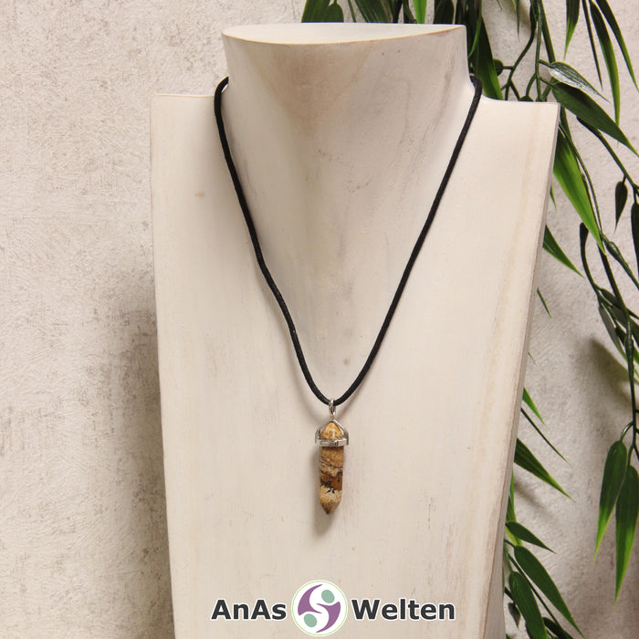 Ein Landschaftsjaspis Stift-Anhänger groß mit Metallöse, der mit einem schwarzen Baumwollband um eine helle Büste gehängt wurde