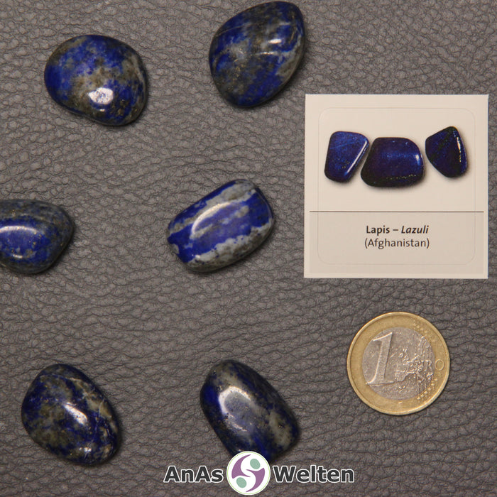 Mehrere Beispiele für den Lapislazuli Trommelstein. Daneben liegt der Sticker.