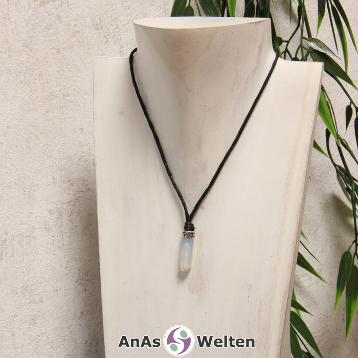 Eine durchsichtig blaue Fluorit Stift-Anhänger klein Kette mit einem Metallelement über dem Edelstein an einer dunklen Büste.