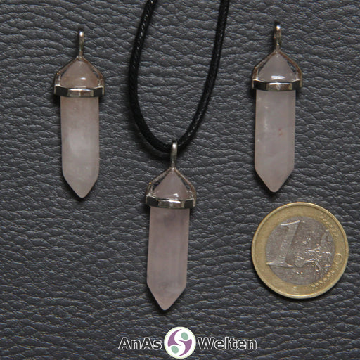 Drei Doppelspitze Stift-Anhänger aus Rosenquarz nebeneinander. Einer befindet sich an einem schwarzen Baumwollband.