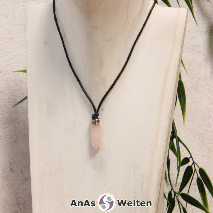 Eine rosa Rosenquarz Stift-Anhänger klein Kette mit einem Metallelement über dem Edelstein an einer hellen Büste.
