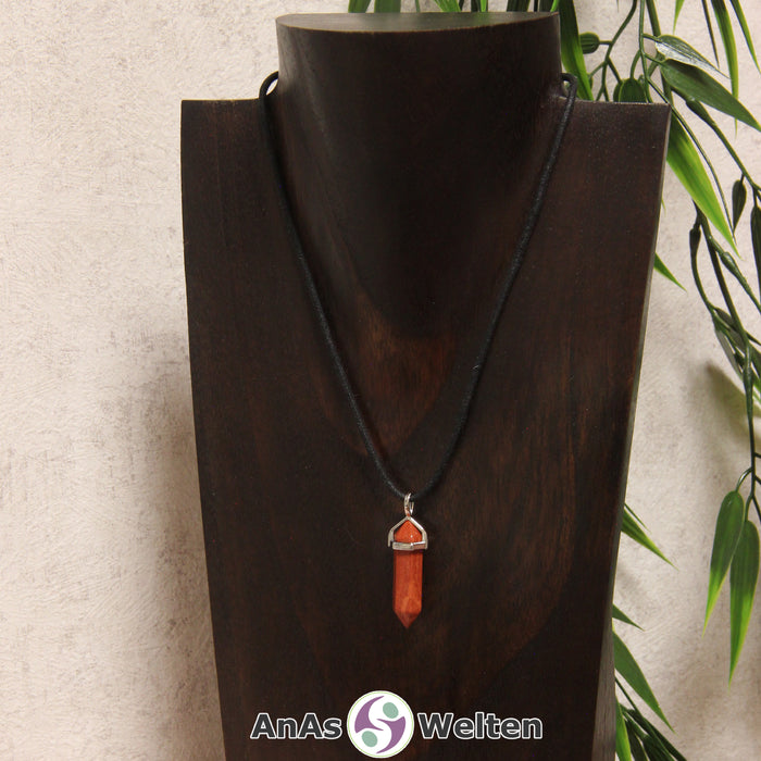 Ein Roter Jaspis Stift-Anhänger groß mit Metallöse, der mit einem schwarzen Baumwollband um eine dunkle Büste gehängt wurde