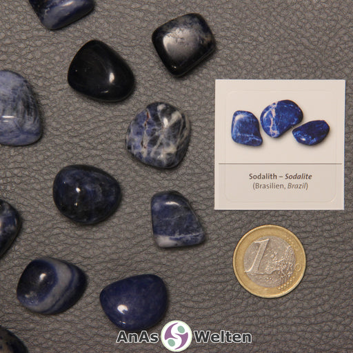 Mehrere Beispiele für den Sodalith Trommelstein. Daneben liegt der Sticker.