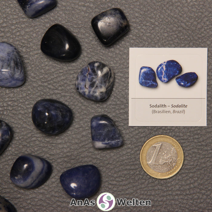 Mehrere Beispiele für den Sodalith Trommelstein. Daneben liegt der Sticker.