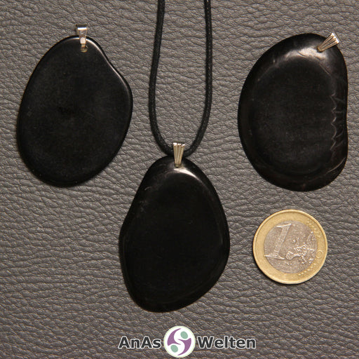 Drei schwarz gefärbte Tagua-Nuss-Scheiben mit Metallöse. Eine ist an einem schwarzen gewachsten Baumwollband.