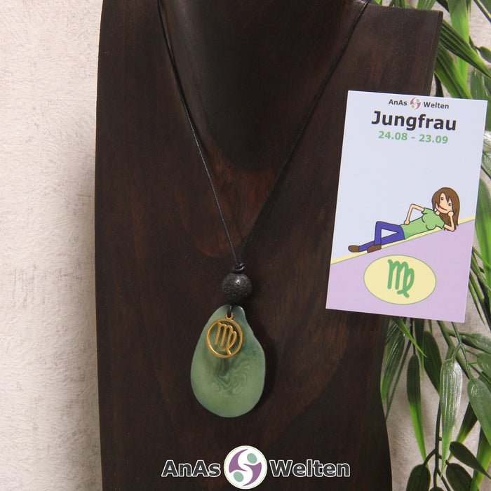 Eine grün gefärbte Tagua-Nuss Sternzeichen Kette mit goldfarbenem Jungfrau-Symbol und Lavakugel an einer dunklen Büste.