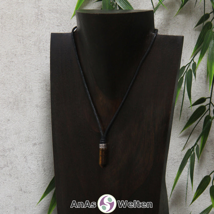 Eine braun schimmernde Tigerauge Stift-Anhänger klein Kette mit einem Metallelement über dem Edelstein an einer dunklen Büste.