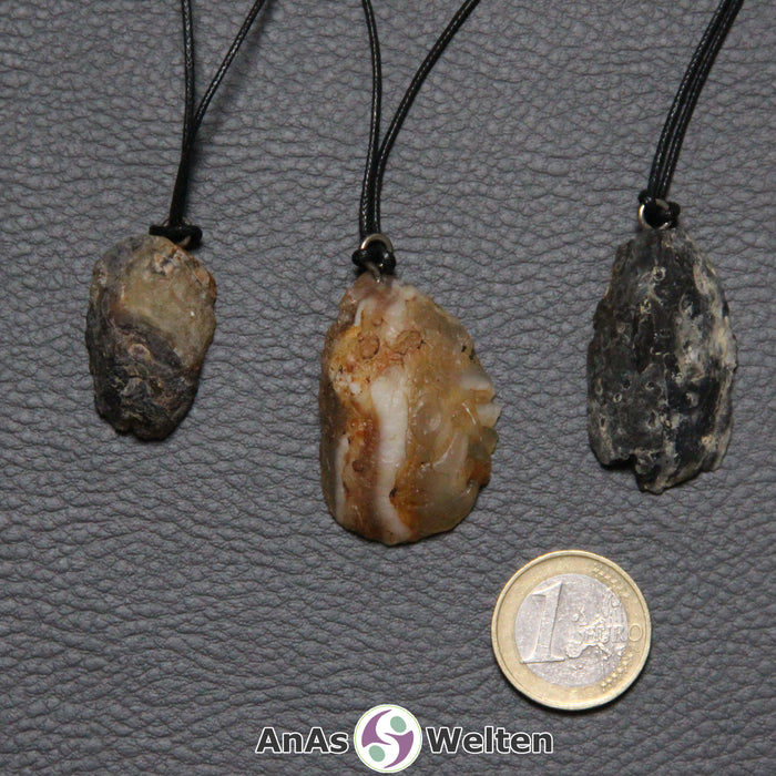 Die Rückseiten der drei beispielhaften Achat Geoden. Sie ist rau und ungeschliffen. Die Farben sind grau-braun und grau-schwarz.