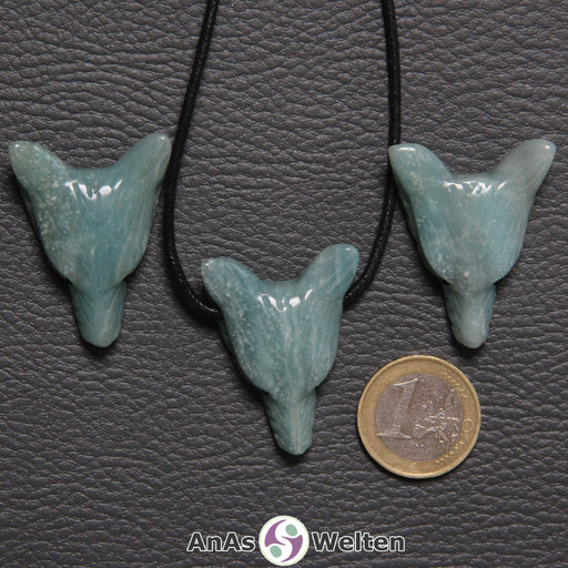 Drei Amazonit Wolf Anhänger nebeneinander. Einer befindet sich an einem schwarzen Baumwollband.