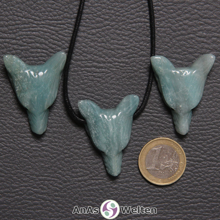 Drei Amazonit Wolf Anhänger nebeneinander. Einer befindet sich an einem schwarzen Baumwollband.