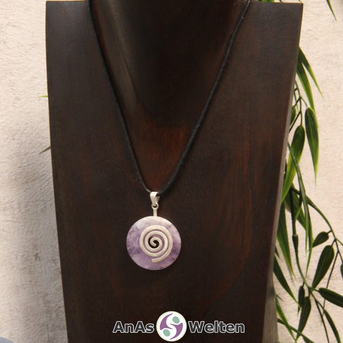 Ein Amethyst Donut an einem Donut-Halter Spirale, der mit einem gewachsten Baumwollband um eine dunkle Büste hängt.