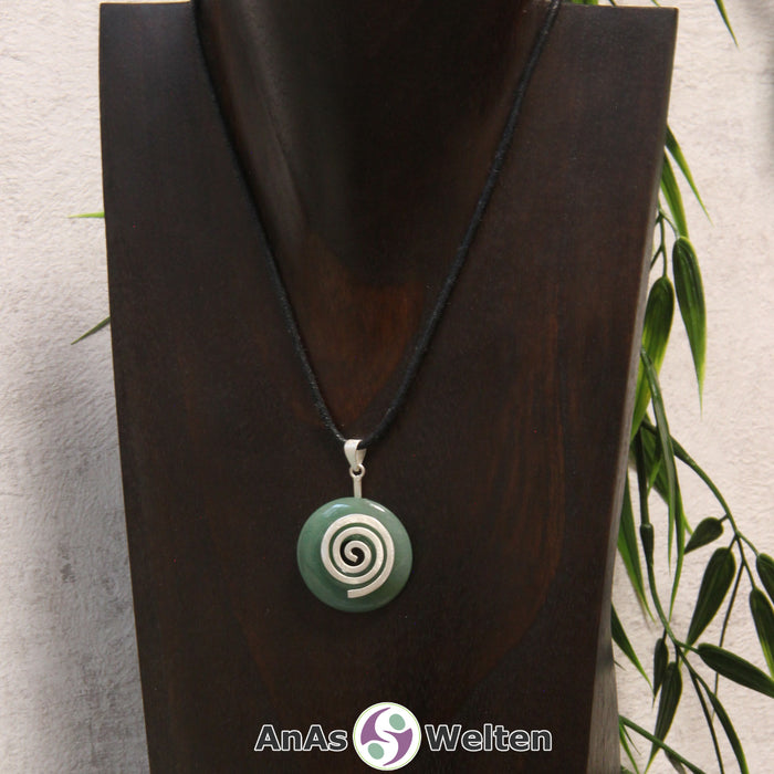 Ein Aventurin Donut an einem Donut-Halter Spirale, der mit einem gewachsten Baumwollband um eine dunkle Büste hängt.