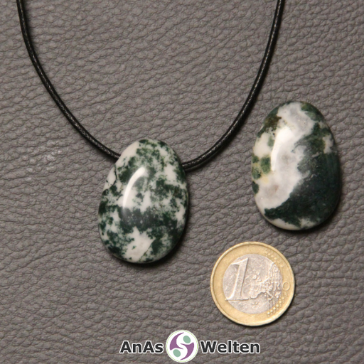 Zwei grün-weiße Moosachat gebohrte Trommelsteine nebeneinander. Einer befindet sich an einem schwarzen gewachsten Baumwollband.