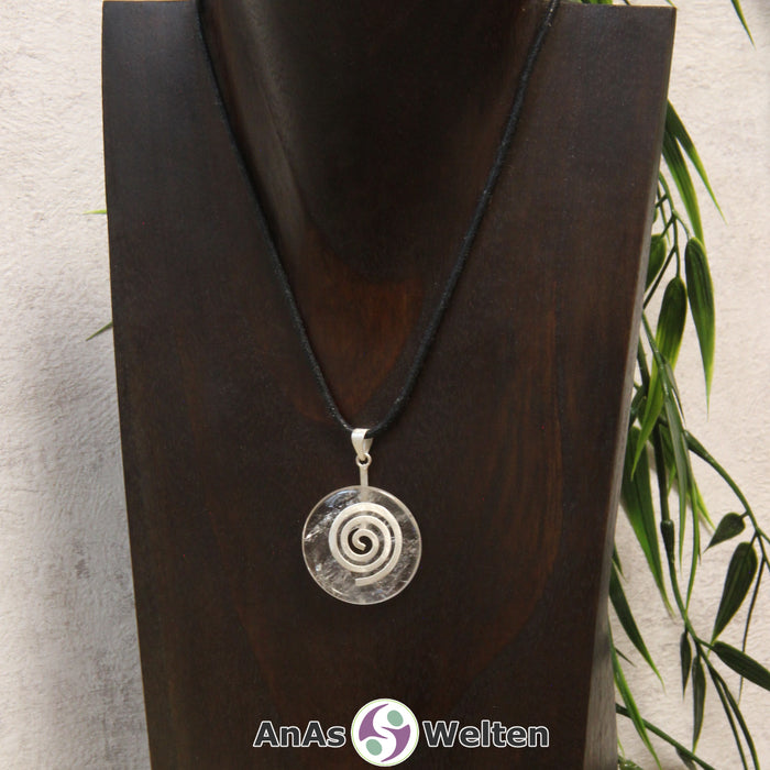 Ein Bergkristall Donut an einem Donut-Halter Spirale, der mit einem gewachsten Baumwollband um eine dunkle Büste hängt.