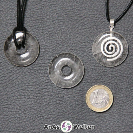 Drei Bergkristall Donuts nebeneinander. Einer an einem Baumwollband, ein anderer an einem Donut-Halter mit Baumwollband.