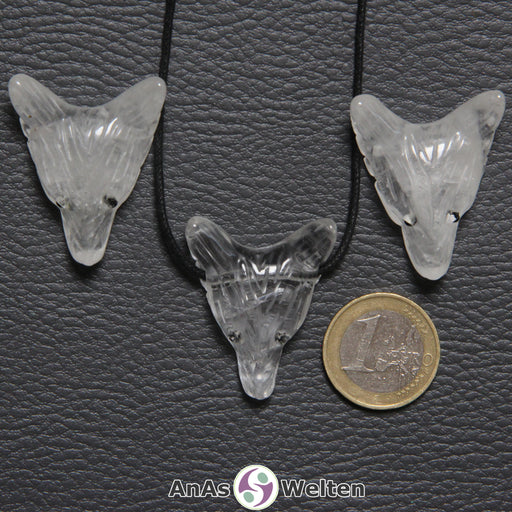 Drei Bergkristall Wolf Anhänger nebeneinander. Einer befindet sich an einem schwarzen Baumwollband.