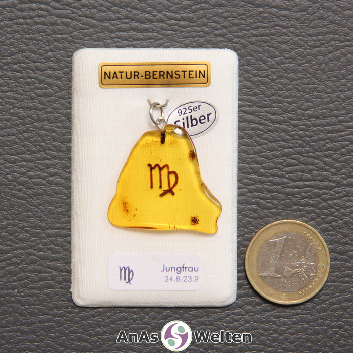Ein Bernstein Anhänger Jungfrau mit Silberöse an einem Display. Das Sternzeichen ist in den Bernstein eingebrannt.