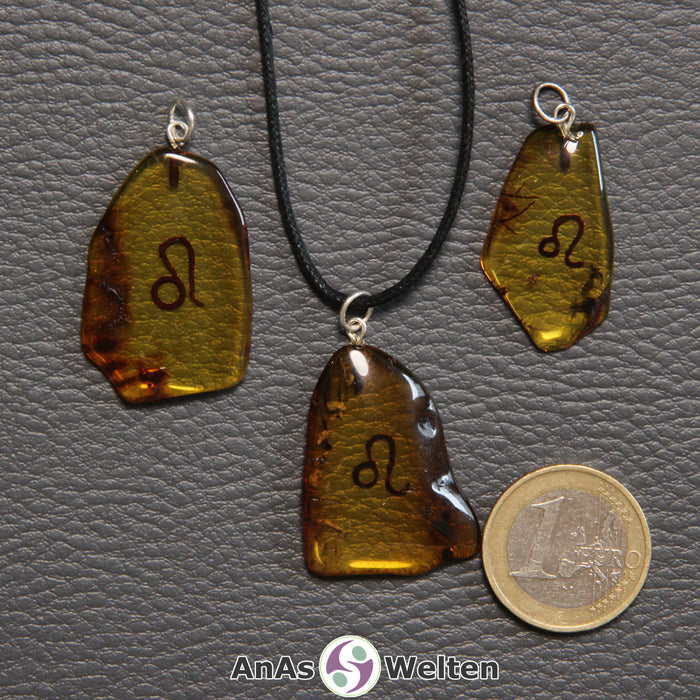 Drei Bernstein Anhänger Löwe in verschiedenen Formen. Das Sternzeichensymbol ist in die Bernsteine eingebrannt.