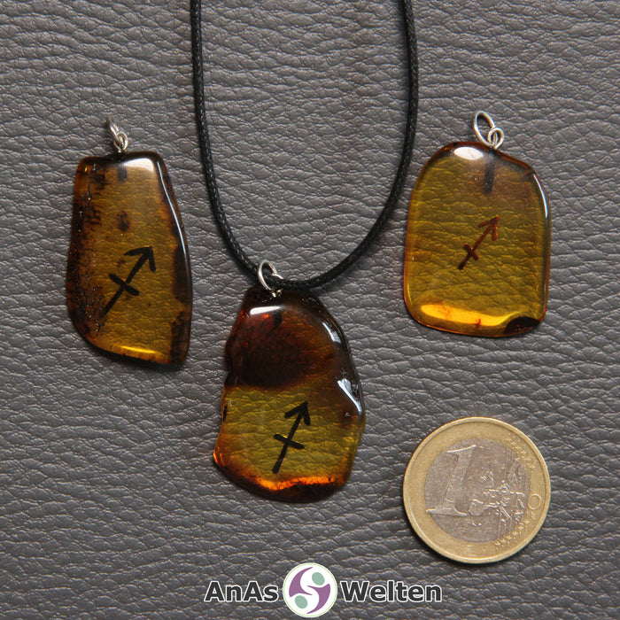 Drei Bernstein Anhänger Schütze in verschiedenen Formen. Das Sternzeichensymbol ist in die Bernsteine eingebrannt.