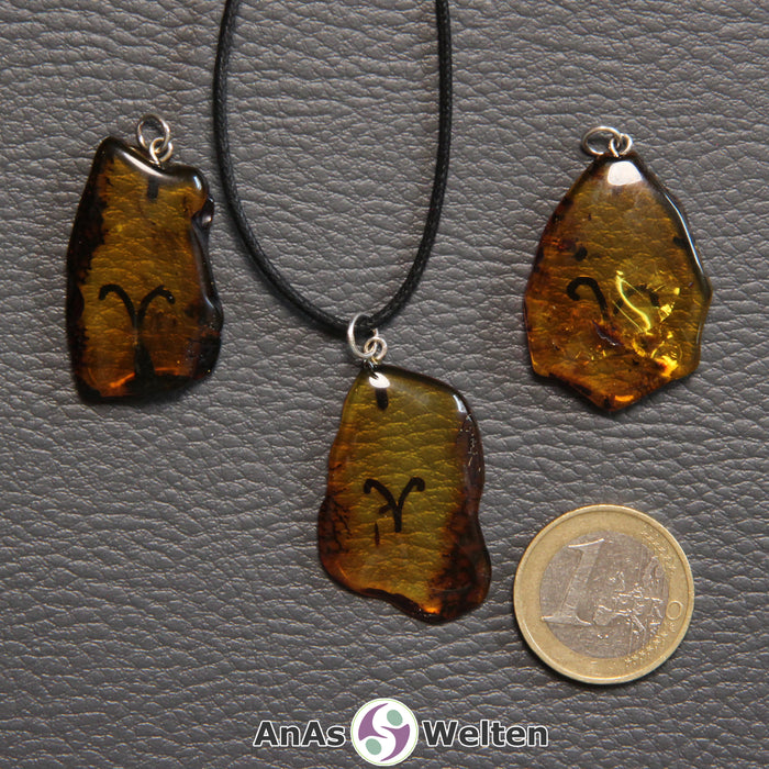 Drei Bernstein Anhänger Widder in verschiedenen Formen. Das Sternzeichensymbol ist in die Bernsteine eingebrannt.