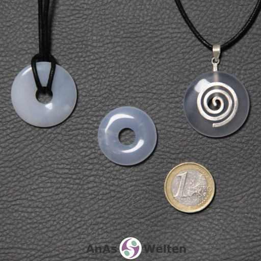 Drei Blauer Chalcedon Donuts nebeneinander. Einer an einem Baumwollband, ein anderer an einem Donut-Halter mit Baumwollband.