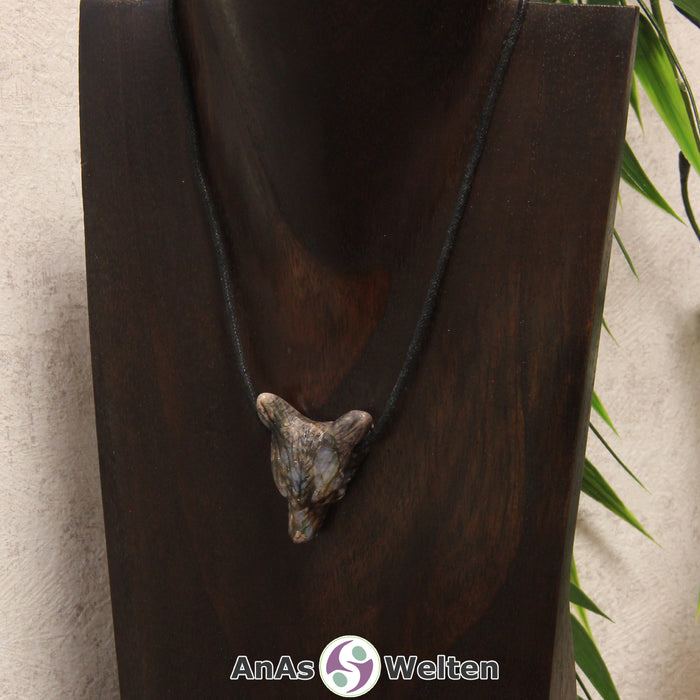 Ein Blue Liberty Wolf Anhänger an einem schwarzen Baumwollband, der um eine dunkle Büste gehängt wurde.