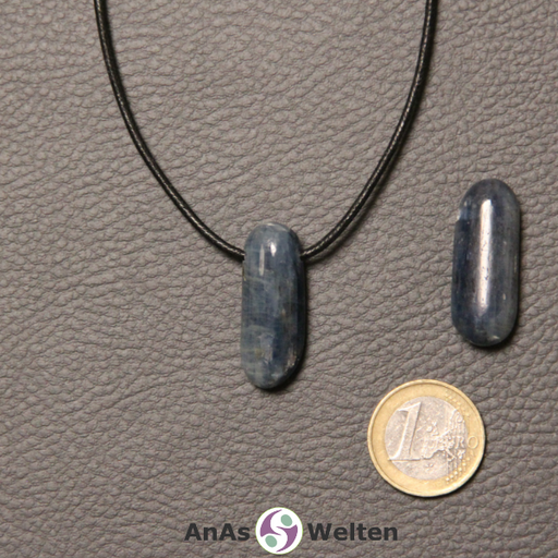 Zwei blaue Disthen gebohrte Trommelsteine nebeneinander. Einer befindet sich an einem schwarzen gewachsten Baumwollband.