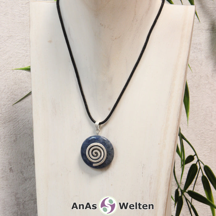 Ein Dumortierit Donut an einem Donut-Halter Spirale, der mit einem gewachsten Baumwollband um eine helle Büste hängt.