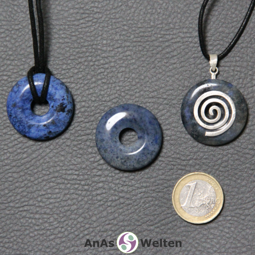 Drei Dumortierit Donuts nebeneinander. Einer an einem Baumwollband, ein anderer an einem Donut-Halter mit Baumwollband.