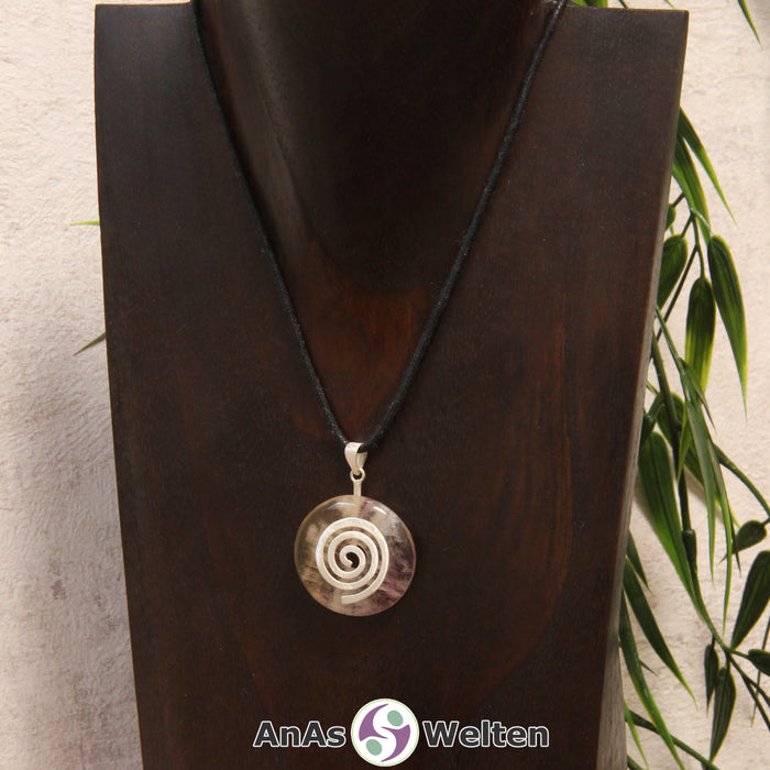 Ein Gelber Fluorit Donut an einem Donut-Halter Spirale, der mit einem gewachsten Baumwollband um eine dunkle Büste hängt.