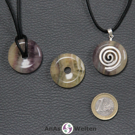 Drei Gelber Fluorit Donuts nebeneinander. Einer an einem Baumwollband, ein anderer an einem Donut-Halter mit Baumwollband.