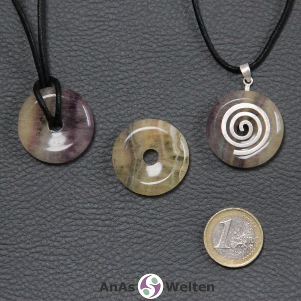 Drei Gelber Fluorit Donuts nebeneinander. Einer an einem Baumwollband, ein anderer an einem Donut-Halter mit Baumwollband.