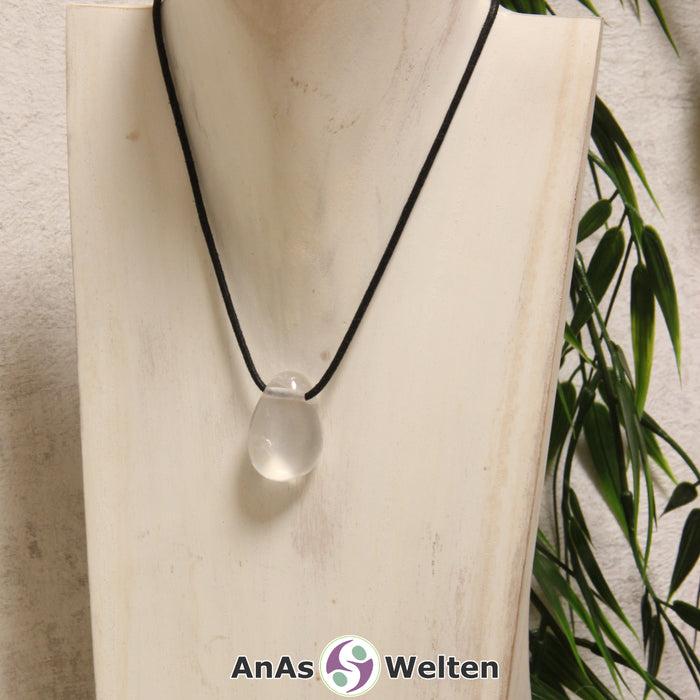 Ein dursichtiger Girasol gebohrter Trommelstein an einem schwarzen Baumwollband, der um eine helle Büste gehängt wurde.