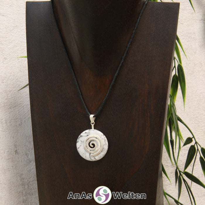 Ein Magnesit Donut an einem Donut-Halter Spirale, der mit einem gewachsten Baumwollband um eine dunkle Büste hängt.