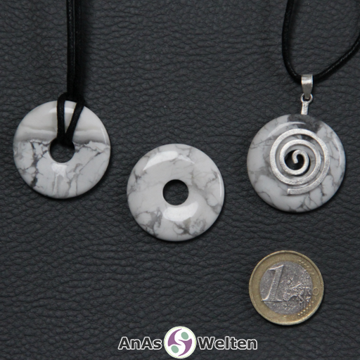 Drei Magnesit Donuts nebeneinander. Einer an einem Baumwollband, ein anderer an einem Donut-Halter mit Baumwollband.