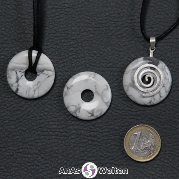 Drei Magnesit Donuts nebeneinander. Einer an einem Baumwollband, ein anderer an einem Donut-Halter mit Baumwollband.