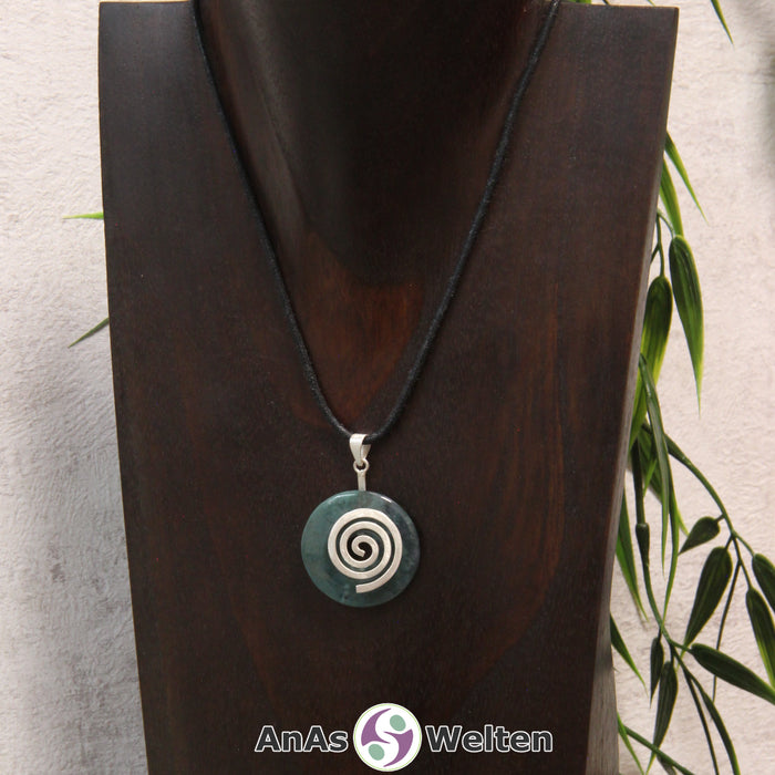 Ein Moosachat Donut an einem Donut-Halter Spirale, der mit einem gewachsten Baumwollband um eine dunkle Büste hängt.