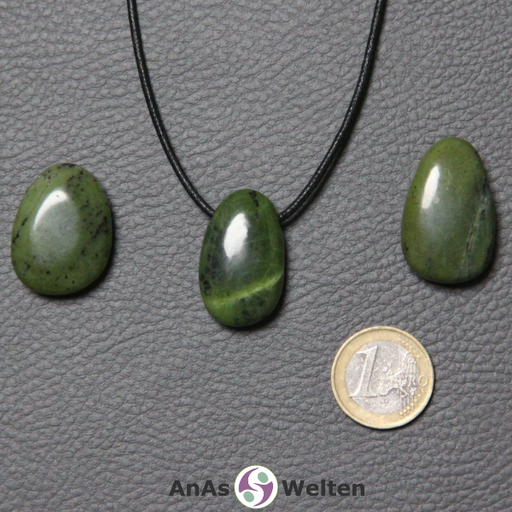 Drei grüne Nephrit Jade gebohrte Trommelsteine nebeneinander. Einer befindet sich an einem schwarzen gewachsten Baumwollband.