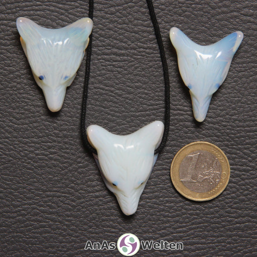 Drei Opalglas Wolf Anhänger nebeneinander. Einer befindet sich an einem schwarzen Baumwollband.